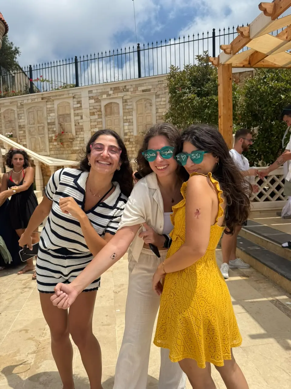 Three friends dressed up at a summer party