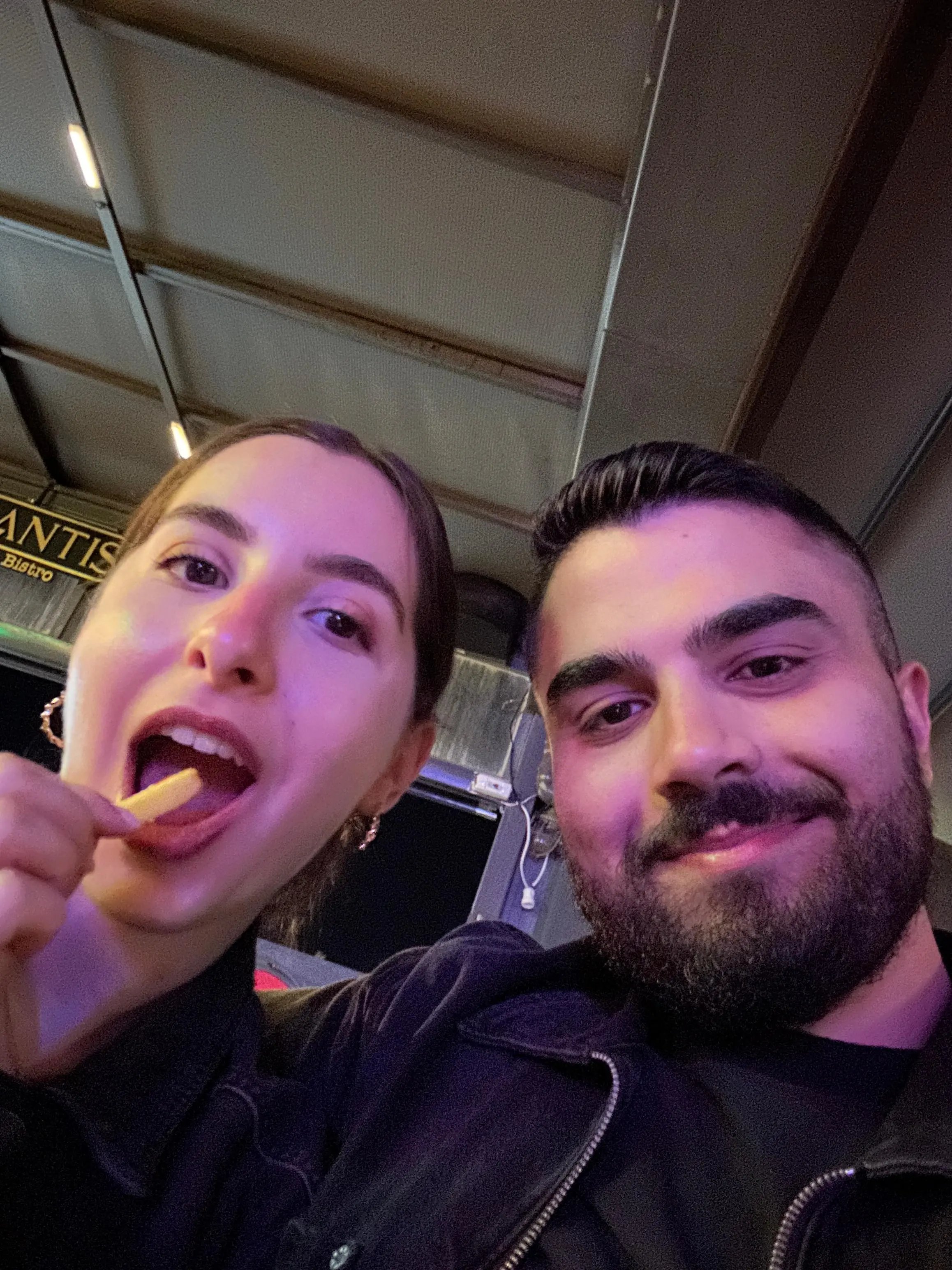 Two friends sharing fries at a bistro