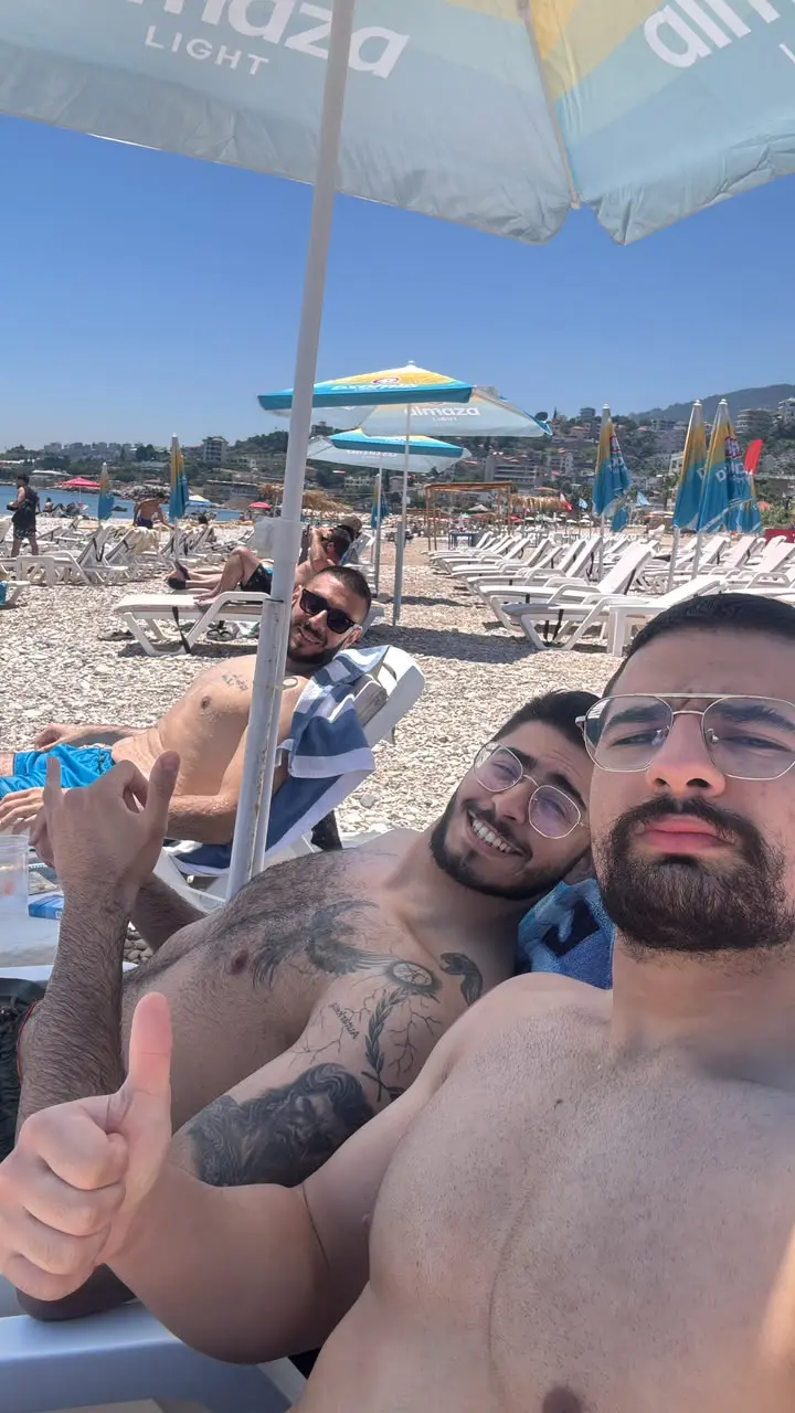 Three friends under a beach umbrella